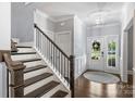 Light-filled foyer featuring hardwood floors, staircase, and a glimpse of the exterior through the front door at 2625 Rea Pond Ct, Charlotte, NC 28226
