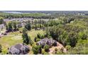 Expansive aerial view of the property with golf course and lake views, surrounded by lush trees and well-manicured lawns at 277 Tradition Dr, Mount Gilead, NC 27306