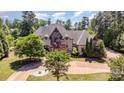Aerial front view of a luxurious home with a circular driveway, beautiful landscaping, and mature trees at 277 Tradition Dr, Mount Gilead, NC 27306