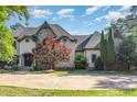Charming home featuring a stone and stucco facade, elegant architectural details, and a well-manicured front yard at 277 Tradition Dr, Mount Gilead, NC 27306