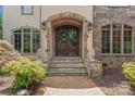 Inviting front entrance with stone archway, double doors, and lion statues, creating a grand arrival at 277 Tradition Dr, Mount Gilead, NC 27306