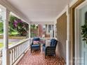 Cozy porch featuring comfortable seating with brick siding and hanging flowers at 2804 Park Rd, Charlotte, NC 28209