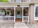 Inviting porch with classic white columns, hanging flower baskets, and a detailed tile floor at 2804 Park Rd, Charlotte, NC 28209