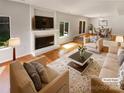 Cozy living room with a fireplace, hardwood floors, and a dining area, virtually staged for a modern look at 3143 Windbluff Dr, Charlotte, NC 28277
