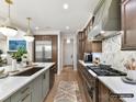 Spacious kitchen featuring stainless appliances, a stylish backsplash, and an island with pendant lighting at 4015 Pritchard Pl, Fort Mill, SC 29715
