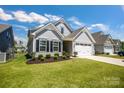 Beautiful one-story home featuring gray siding, a manicured lawn, and an attached two-car garage at 5112 Larewood Dr, Charlotte, NC 28215