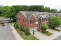 Aerial view of brick townhomes with two-car garages, landscaping, and street access at 5422 Shannon Bell Ln, Charlotte, NC 28277