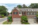Daytime shot of a brick townhome featuring a two-car garage, landscaping, and street signage at 5422 Shannon Bell Ln, Charlotte, NC 28277