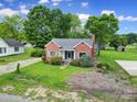 Charming brick home with manicured lawn and blue shutters, nestled amid lush green trees and blue skies on a sunny day at 5573 Main St, Fort Lawn, SC 29714