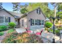 Inviting patio featuring a table with red chairs, well-maintained garden, and charming brick facade at 6005 Bryant Ln, Waxhaw, NC 28173