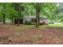View of rear exterior elevation featuring a screened-in porch, red stairs, and mature trees at 6804 Lineberger Rd, Denver, NC 28037