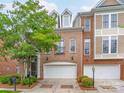 Brick townhome with a two-car garage, manicured landscaping, and dormer windows at 7722 Springs Village Ln # 40, Charlotte, NC 28226