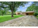 Inviting brick home with mature shade trees, long driveway and carport offering a warm, established feel at 812 Clinton Ave, Lancaster, SC 29720