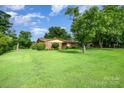 Traditional brick home with mature trees, manicured lawn, and landscaping, creating a welcoming curb appeal at 812 Clinton Ave, Lancaster, SC 29720