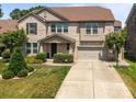 Two-story brick home with a well-manicured lawn, two-car garage, and basketball hoop at 8614 Goodman Park Ct, Charlotte, NC 28277