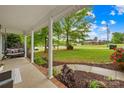 Relaxing covered front porch with a swing and views of the landscaped yard at 1013 E Academy St, Cherryville, NC 28021