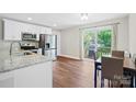 Bright eat-in kitchen with stainless appliances, granite countertops, and sliding glass doors to deck at 1013 Old Charlotte Rd, Statesville, NC 28677