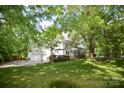 Expansive backyard featuring a spacious lawn, mature trees, and a white two-story house at 1023 Evian Ln, Matthews, NC 28105
