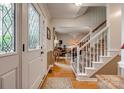 Bright foyer with hardwood floors, leaded glass door, and staircase leading to upper level at 1023 Evian Ln, Matthews, NC 28105