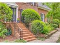 Close-up view of the brick stairs leading to the front door, framed by lush greenery at 1023 Evian Ln, Matthews, NC 28105