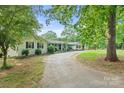 View of home on a tree-covered lot with an extended driveway and well-maintained lawn at 108 Augusta Dr, Statesville, NC 28625