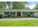 Charming one-story home with light blue siding, mature landscaping, a welcoming entrance and a well-manicured lawn at 108 Augusta Dr, Statesville, NC 28625