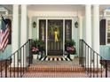 Welcoming front porch featuring a black front door with floral accents, a black railing, and potted flowers at 108 Augusta Dr, Statesville, NC 28625
