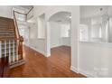Spacious interior with hardwood floors, staircase, and arched doorways create an open and inviting atmosphere at 12802 Waterlyn Club Dr, Charlotte, NC 28278
