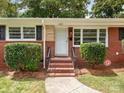 Close up of front door with brick steps and established landscaping at 1422 Burnley Rd, Charlotte, NC 28210
