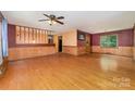 Spacious living room showcasing hardwood floors, wainscoting, and a ceiling fan at 154 Seven Oaks Ln, Statesville, NC 28677