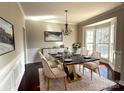 Elegant dining room with a modern chandelier, a black and gold table set for six, and a decorative buffet at 16446 Doves Canyon Ln, Charlotte, NC 28278