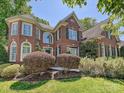 A stately brick home featuring manicured landscaping and timeless architectural details at 16511 Bridgehampton Club Dr, Charlotte, NC 28277