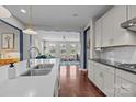 Bright kitchen features white cabinets, countertops, and hardwood floors that lead into the living room at 17513 Julees Walk Ln, Davidson, NC 28036