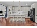 Bright kitchen features white cabinets, a large island with seating, and stainless steel appliances at 17513 Julees Walk Ln, Davidson, NC 28036