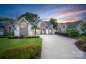 Stunning home exterior featuring stone accents, manicured lawn, and circular driveway at 17819 John Connor Rd, Cornelius, NC 28031