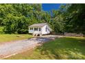 Exterior view of the charming home with gravel driveway and surrounding trees at 201 Trinity St, Clover, SC 29710
