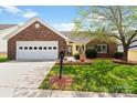 Charming single-story home featuring a brick facade, well-manicured lawn and attached garage with carriage door at 202 Pond View Dr, Salisbury, NC 28147