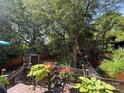 Private backyard with mature trees, a wooden deck with decorative plants, and a storage shed at 2112 Bay St, Charlotte, NC 28205
