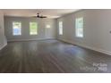Spacious living room boasts new hardwood flooring and abundant natural light from three windows at 28770 Hwy 73 Hwy, Albemarle, NC 28001