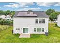 Rear view of the home with solar panels, a manicured lawn and privacy fence at 3038 Old Ironside Dr, Charlotte, NC 28213