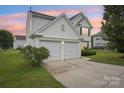 Charming two-story home with a two-car garage, manicured lawn and long driveway at 3038 Old Ironside Dr, Charlotte, NC 28213