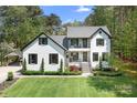 Beautiful two-story white brick home featuring black shutters and a well-manicured lawn at 317 Marietta Rd, Mooresville, NC 28117
