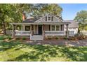 Beautiful home featuring a covered porch with stone accents and lush landscaping at 319 N Central Ave, Locust, NC 28097