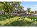 Inviting home featuring a covered porch, manicured lawn and mature trees at 319 N Central Ave, Locust, NC 28097
