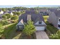 Aerial view of gray sided home featuring a manicured lawn, mature landscaping and a two-car garage at 3267 Lock Erne Ave, Kannapolis, NC 28081