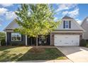 Inviting home featuring stone accents, a two-car garage, and professionally landscaped lawn at 3267 Lock Erne Ave, Kannapolis, NC 28081