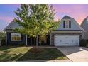 Charming home featuring gray siding, stone accents, manicured lawn, and a two-car garage at 3267 Lock Erne Ave, Kannapolis, NC 28081