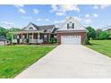Inviting brick home with a spacious driveway leading to an attached garage and a welcoming front porch at 34843 Ellis Spring Ct, Albemarle, NC 28001