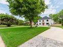 Inviting home with a lush green lawn, mature trees, and a circular water feature in the yard at 3501 Providence Rd, Charlotte, NC 28211