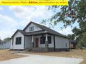 Beautifully constructed white home featuring a covered front porch and an inviting red door at 408 N Peterson St, Stanley, NC 28164
